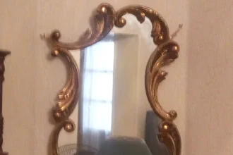 A photo of an unusual old mirror showing an apparently empty room